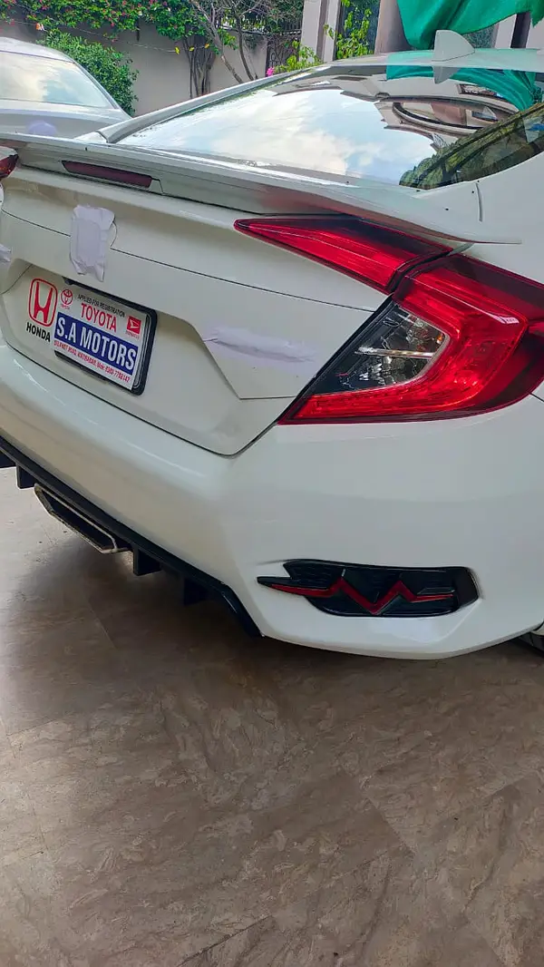 Side profile of white Honda Civic parked in city